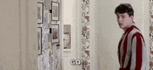 Movie gif. Matthew Broderick as Ferris Bueller in Ferris Bueller’s Day Off wears a red and white striped robe. He looks at us with an annoyed look as he walks away into a room. He says, “Go!” and makes a shooing motion with his hand.