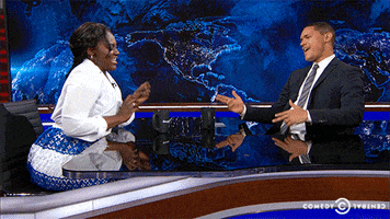 TV gif. Danielle Brooks on The Daily Show with Trevor Noah. Both have double finger guns out and are grooving in sync with one another, rolling their shoulders and grinning.