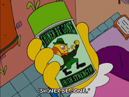 The Simpsons gif. Someone holds a green-capped can of “Irish strength shiner-be-gone” featuring a leprechaun holding up his fists, ready to fight. Text, “Shiner be gone.”
