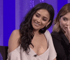 Celebrity gif. Shay Mitchell on a panel at the Paley Center for Media looking over at someone with gratitude and touching her hand to her heart.