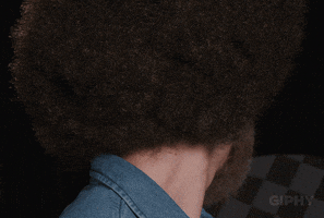 Video gif. A man dressed like Bob Ross turns his head around and nods with confidence.