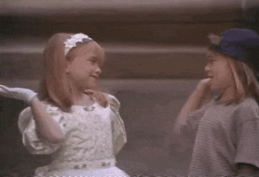 Movie gif. Mary Kate and Ashley Olsen, as Amanda and Alyssa in It Takes Two high five and shake hands.