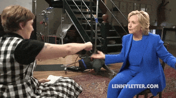 Political gif. Hillary Clinton and Lena Dunham lean forward and do a fist bump.