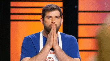 Reality TV gif. Season 6 Masterchef contestant Jesse Romero presses his palms together in silent prayer. 