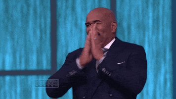 Celebrity gif. Steve Harvey looks around at the audience and claps fastly with a big, cheesy smile on his face. 