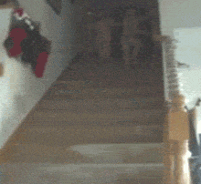 Video gif. Two children run down the stairs, Christmas morning. The young girl trips and flips all the way on her head, then back on her butt. The boy watches her fall.