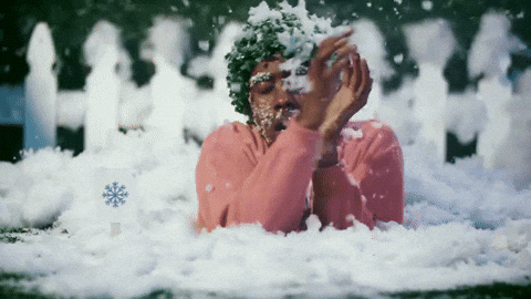 a woman is laying in the snow with snow on her face .