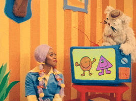 TV gif. Scruffy, a fluffy dog puppet, sits on top of a TV in "Happy Place," switching it off as he says "Go to Sleep!" in a living room decorated with bright cartoonish decor. An adult woman wearing a denim shirt with lavender pigtails folds her arms and pouts like a child when the TV is turned off. 