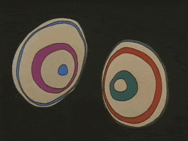 Cartoon gif. Two wide-open eyeballs with rapidly expanding and contracting rings of purple, blue, red, and green, from Fritz the Cat, against a black background.