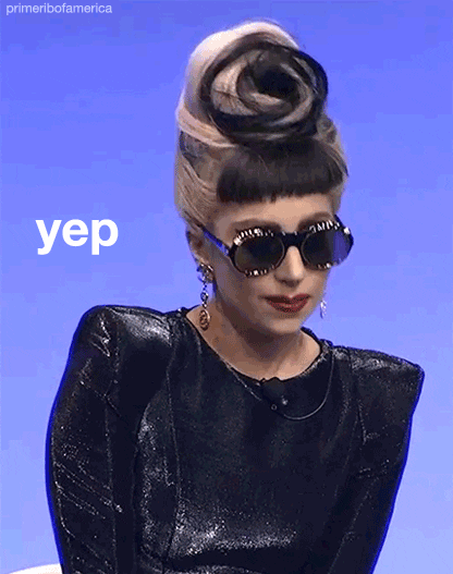 Celebrity gif. Lady Gaga sits for an interview with oversized dark sunglasses and a black gown with pointed shoulders. She nods her head in a big dramatic way with a neutral expression on her face. Text, "yep."