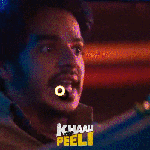 Video gif. Lights flash rainbow colors as a man with wide eyes looks around the room as he yells, “Oh teri!!”