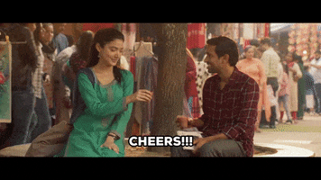 Movie gif. Ipsita Chakravarty as Shreya and Vikrant Massey as Shaan in Gulabo Sitabo. They're sitting on a bench and cheers a steaming cup of tea. They both smile at each other in a flirtatious way. Text, "Cheers!!!'