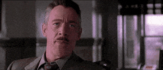 Movie gif. JK Simmons as Jonah and Tobey Maguire as Peter in Spider-Man. Jonah stares at Peter before laughing in his face, mocking and undermining him.